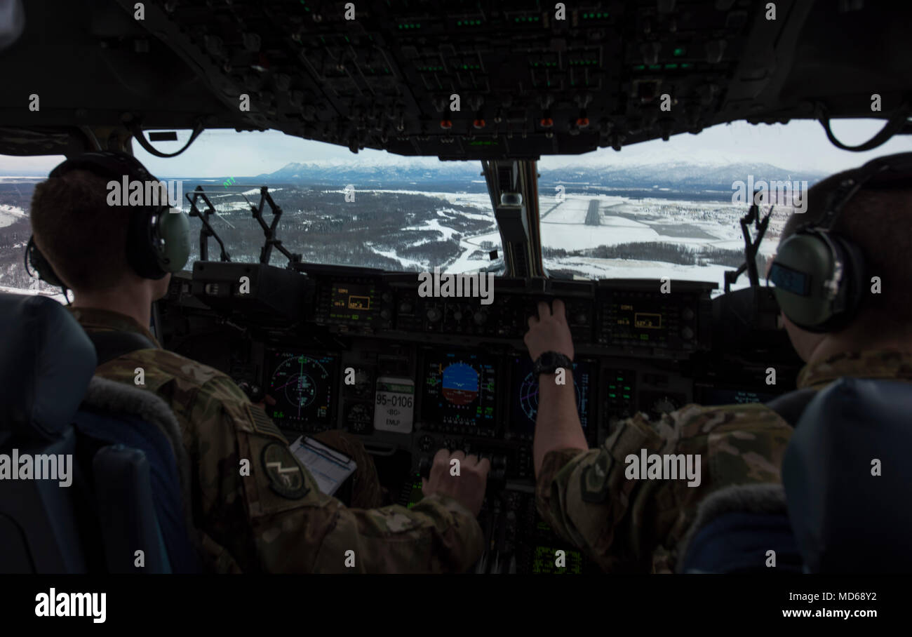 Le capitaine de l'US Air Force Alex Hoffman (à gauche), 7e Escadron de transport aérien, pilote et le Capitaine Richard Elliot, 8e Escadron de transport aérien pilote instructeur, commencer un travail décent dans un C-17 Globemaster III de Eielson Air Force Base, Alaska, le 11 mars 2018. Aviateurs affectés à la 62e Escadre de transport aérien s'est rendu à Eielson dans le cadre de l'exercice pratique de l'Arctique à Pegasus opérations par temps froid. (U.S. Photo de l'Armée de l'air par la Haute Airman Tryphena Mayhugh) Banque D'Images