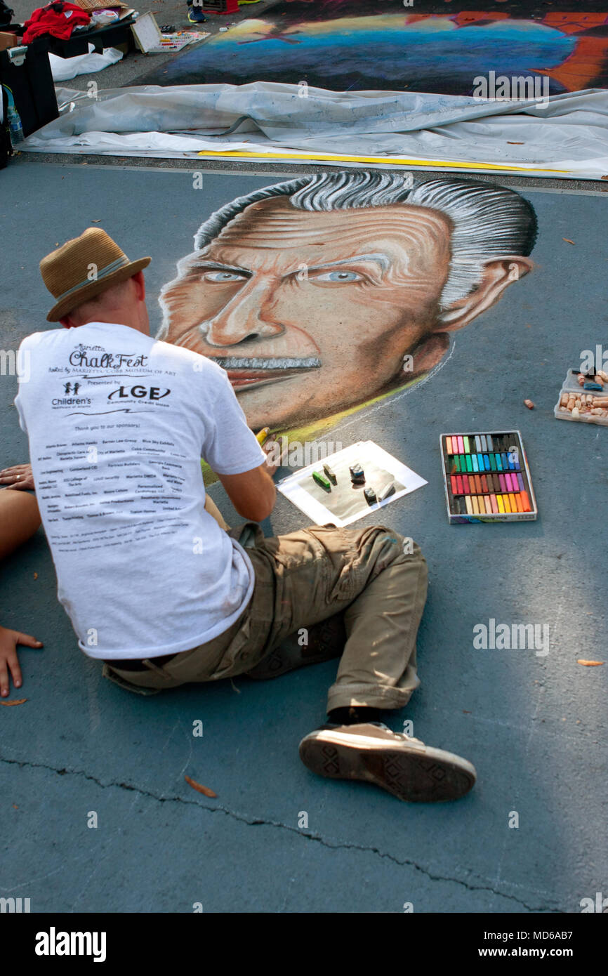 Un artiste à la craie dessine une image de l'icône du film d'horreur Vincent Price sur une rue du centre-ville dans un concours de dessins à la craie, le 11 octobre 2014 à Marietta, GA. Banque D'Images