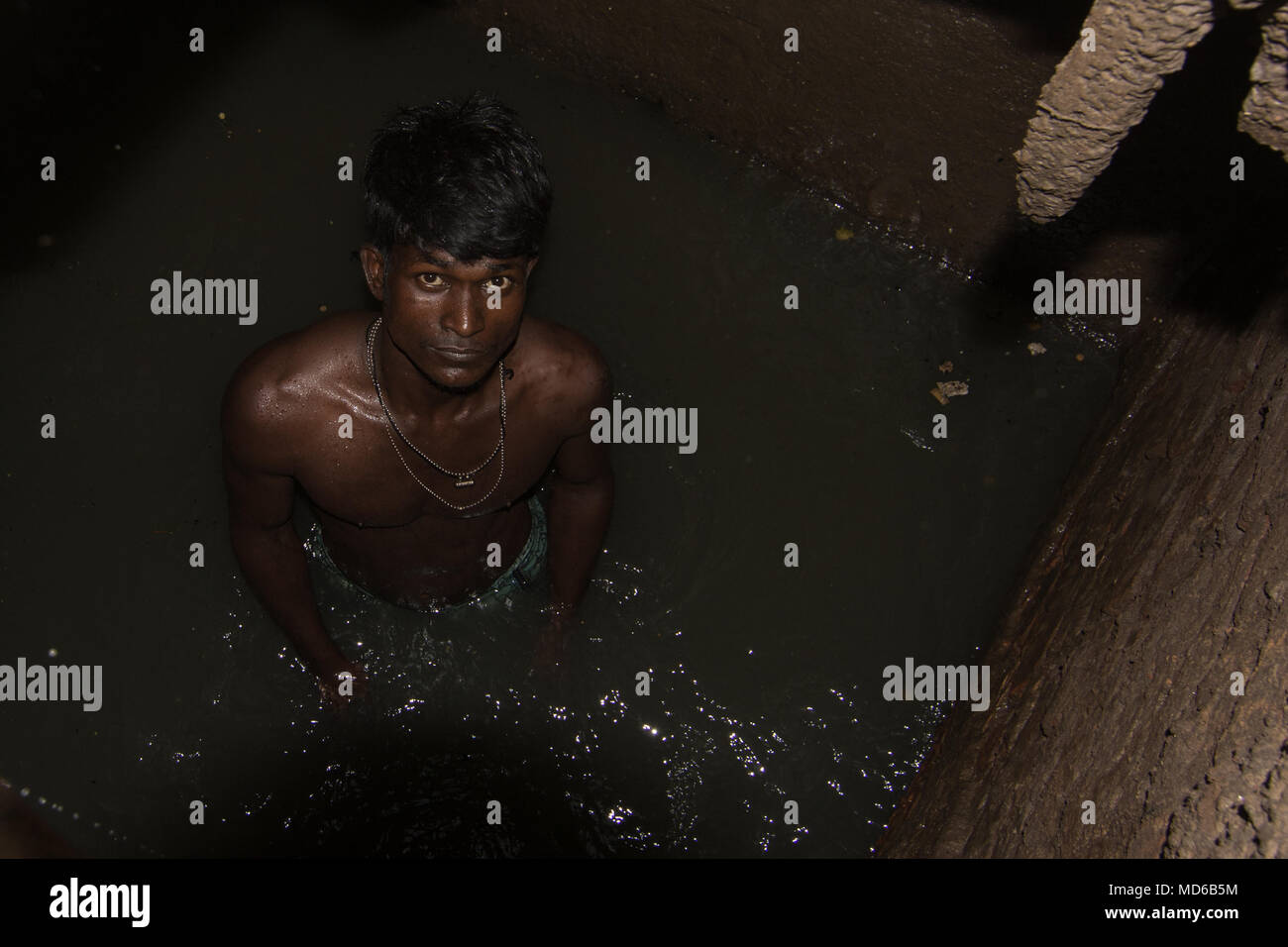 Pire métier du monde, plongée vers le bas dans un trou de boue avec ses  mains nues, une pensée pour ce pauvre nettoyeur d'égout au Bangladesh Photo  Stock - Alamy