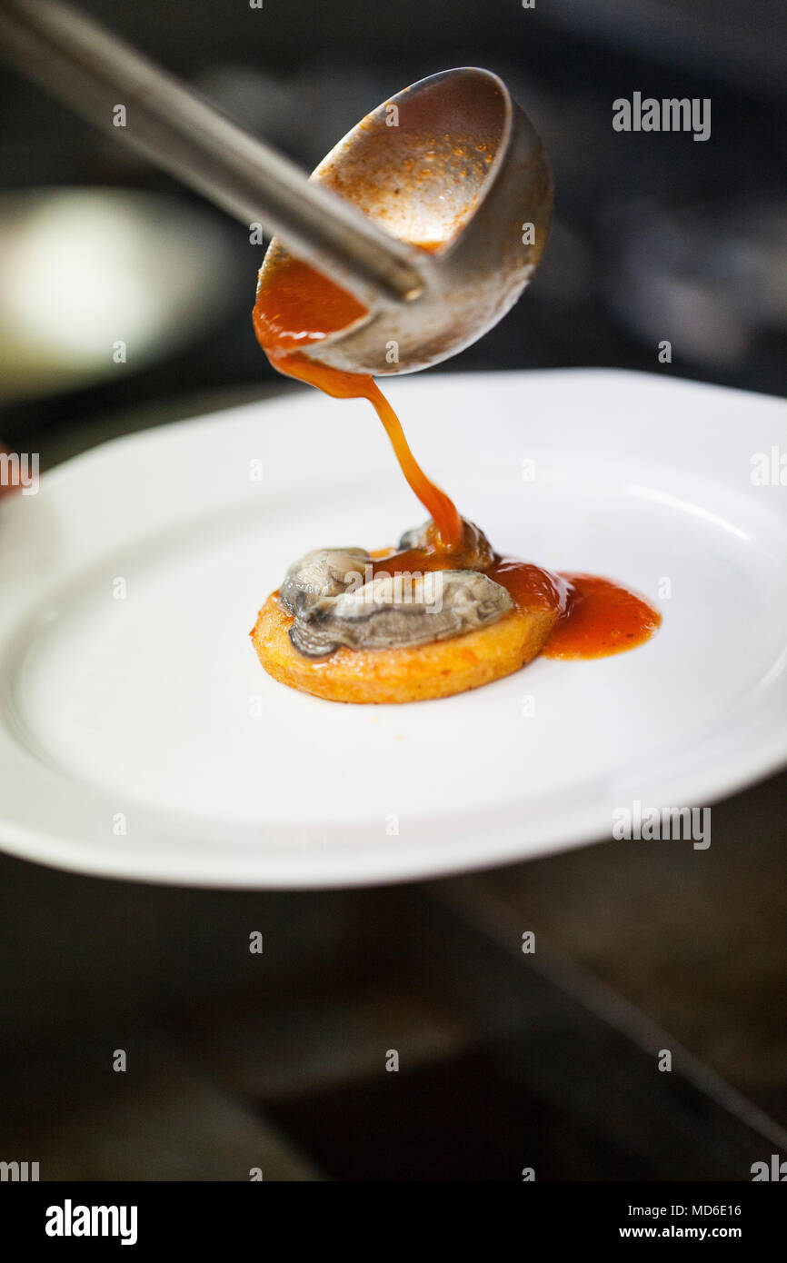 Oyster sopes étant couvert avec une sauce tomate Restaurant El Delfin, San Blas, Riviera Nayarit, Mexique Banque D'Images