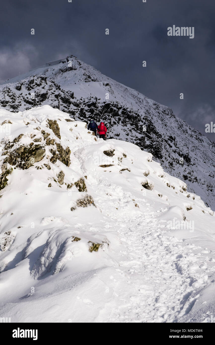 Randonnée Les randonneurs jusqu'à la colline sur la crête du sud au sommet de Principal Bwlch du Mont Snowdon avec de la neige en hiver dans le parc national de Snowdonia. Gwynedd au Pays de Galles Royaume-uni Grande-Bretagne Banque D'Images