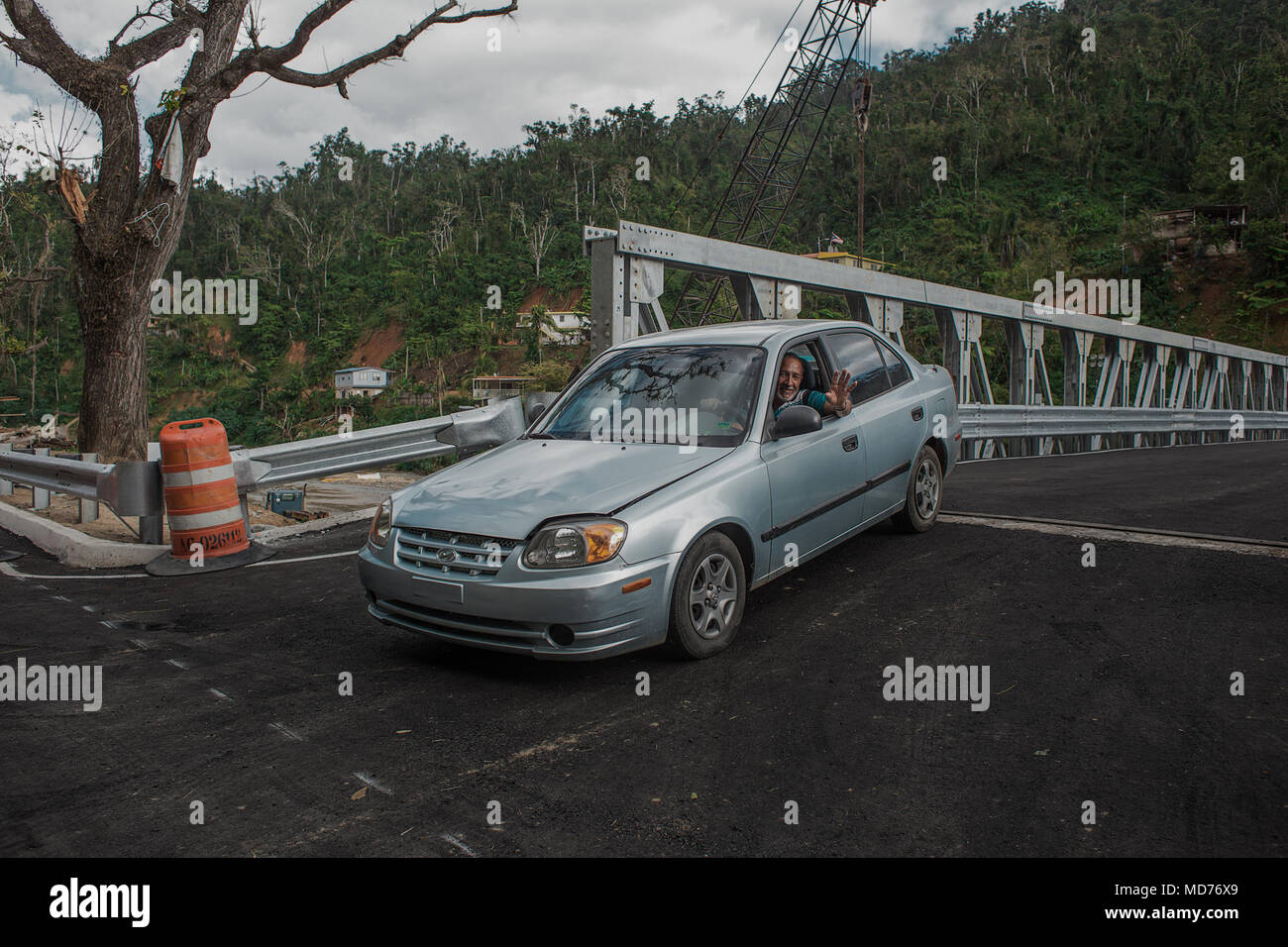 Utuado, Puerto Rico. 13 mars 2018--un heureux résident de Río Abajo est l'un des premiers à conduire sa voiture à travers le nouveau pont construit dans sa communauté. Après l'Ouragan María a ravagé l'île, les fortes pluies s'est effondré le pont précédent laissant plus de 25 familles isolées. Aujourd'hui, grâce aux efforts des collectivités locales, organismes fédéraux et d'état, la communauté a un nouveau pont. La FEMA/Eduardo Martínez Banque D'Images