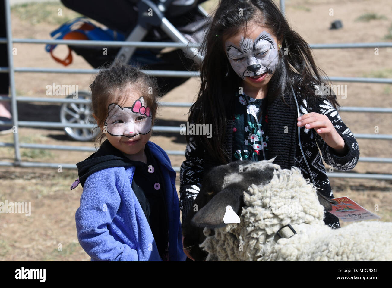 Natalie et Kaylee Garcia (3 et 7 respectivement), un animal de moutons durant le 50e Escadron de soutien de la Force de l'événement Spring Fling à Schriever Air Force Base, Colorado, le 24 mars 2018. Les enfants ont la chance d'interagir avec une variété d'animaux au cours de l'événement et d'obtenir leurs visages peints comme des animaux. (U.S. Air Force photo par Navigant de première classe William Tracy) Banque D'Images