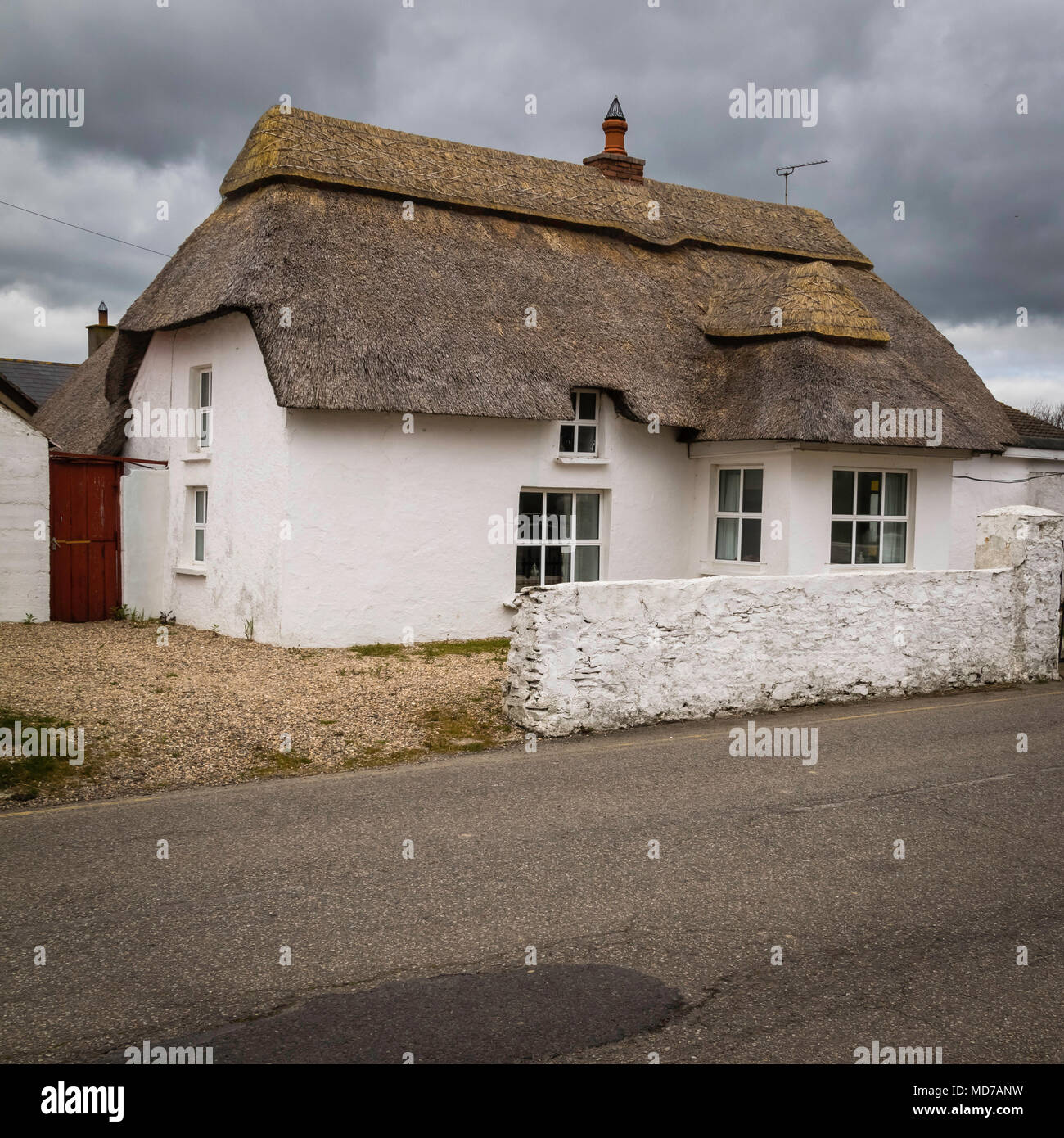 Cottage au toit de chaume traditionnel, Blanc, ciel d'orage spectaculaire, le printemps Banque D'Images
