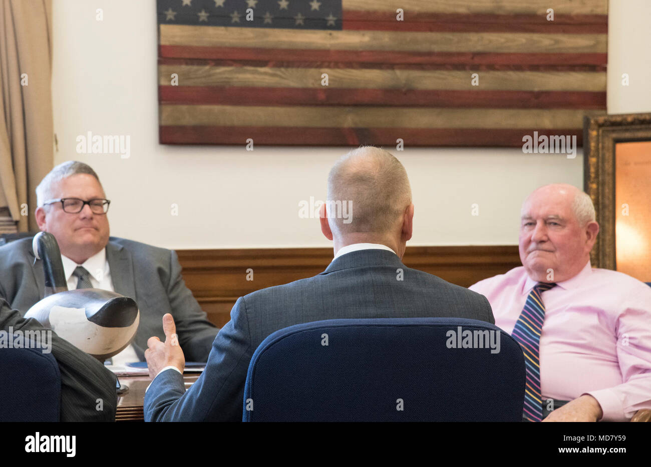 National Fish and Wildlife Foundation (NFWF) Directeur exécutif Jeff Trandahl parler le secrétaire à l'Agriculture des États-Unis Sonny Perdue, à droite, et le sous-secrétaire pour la ferme et Foreign Agricultural Service Bill Northey au ministère de l'Agriculture des États-Unis (USDA) siège à Washington, D.C., le 23 mars 2018. La NFWF était affrété par le Congrès en 1984 pour protéger et assainir les poissons, la faune, les plantes et les habitats. En collaborant avec les partenaires, les entreprises et les particuliers, NFWF a financé plus de 4 500 organisations et engagé plus de 3,8 milliards de dollars à des projets de conservation. Lea Banque D'Images