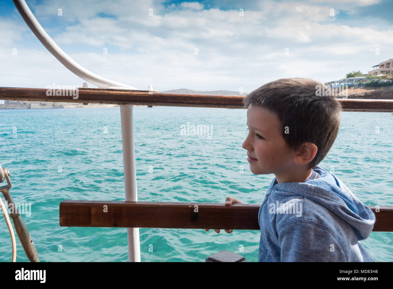 Boy looking at view d'un navire de croisière à Spinalonga, Crète, Grèce Banque D'Images