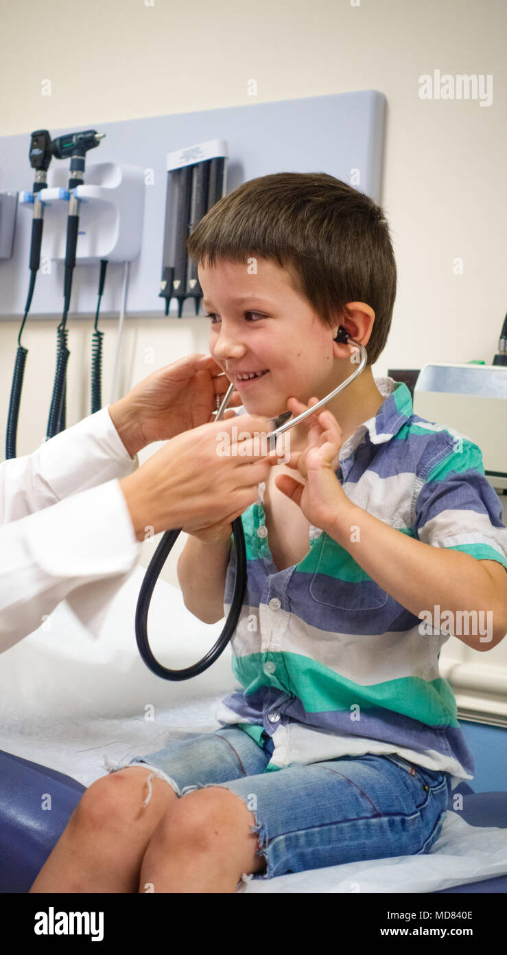 Médecin avec petit garçon à l'écoute à l'aide d'heartbeat stethoscope Banque D'Images