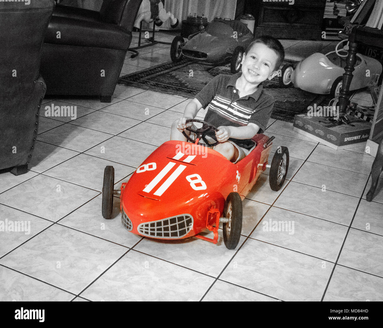 Happy little boy riding voiture jouet à la maison Banque D'Images