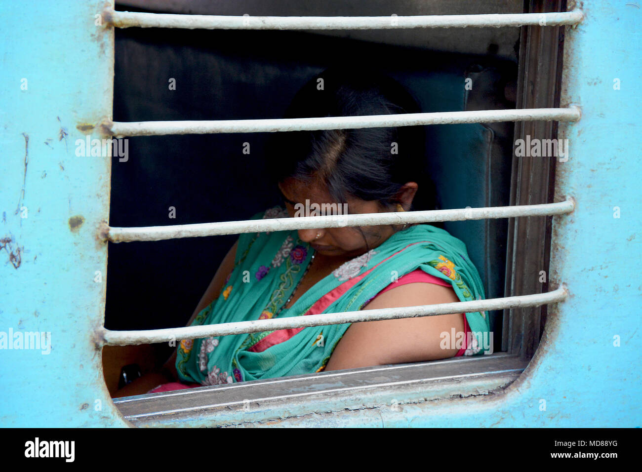 Femme aslee vu à travers la fenêtre d'un train indien Banque D'Images