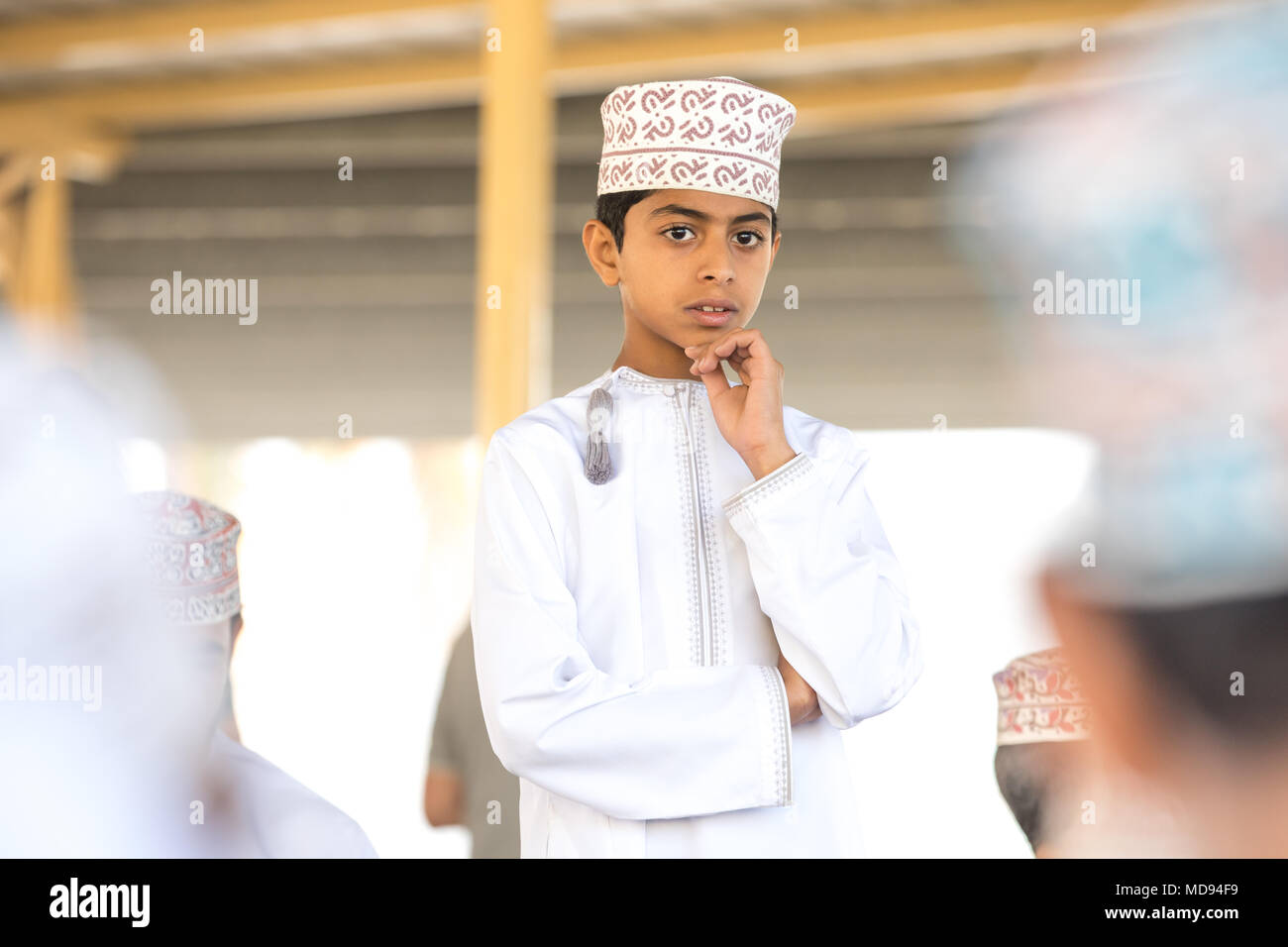 Nizwa, Oman - Mar 23, 2018 : les jeunes Omanais réfléchie garçon en costume traditionnel omanais - kandura blanche. Banque D'Images