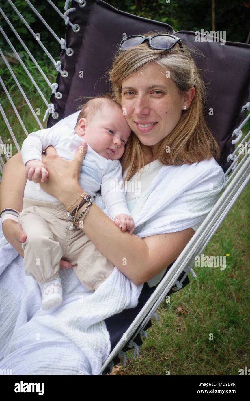 Mère avec cute baby boy de détente sur chaise hamac Banque D'Images