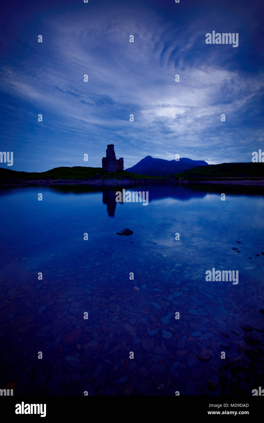 Ardvreck Castle et le Loch Assynt après le coucher du soleil sur la côte Nord 500. Le château et la montagne se reflètent dans le lac Banque D'Images