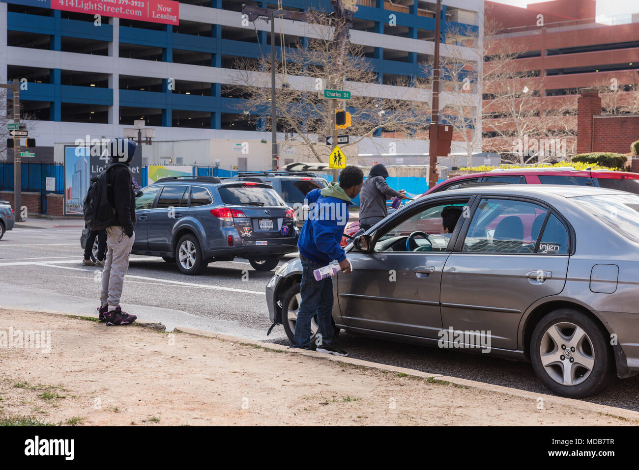 Baltimore, Maryland. Les jeunes hommes gagner de l'argent voiture nettoyage windows sur coin de rue. Banque D'Images