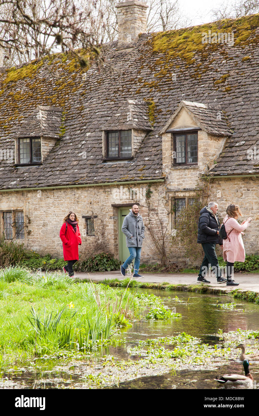 Les gens marchant le long de la rivière Coln à l'extérieur d'Arlington rangée dans le village anglais Cotswold de Bibury Gloucestershire appartenant au National Trust Banque D'Images