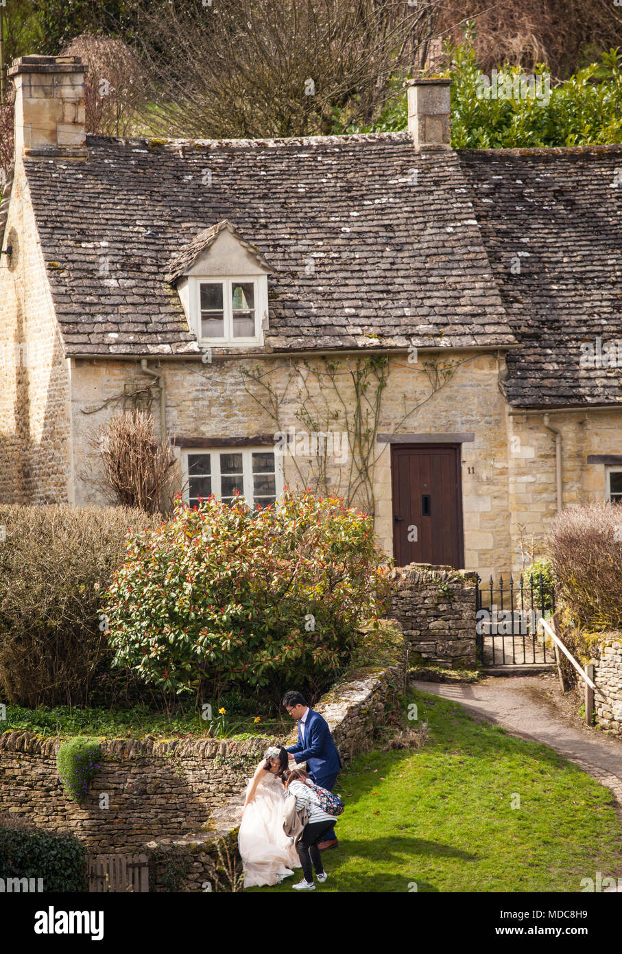 Asian Bride and Groom posent pour les photographies de mariage dans le village de Cotswold Anglais Bibury Gloucestershire Banque D'Images