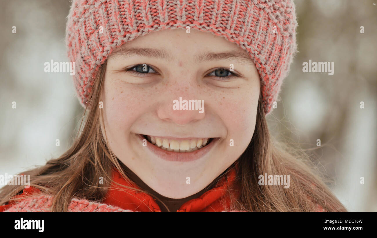 Portrait d'une jeune écolière avec rousseur dans les bois en hiver. La  jeune fille touche son nez avec sa main dans le moufle Photo Stock - Alamy