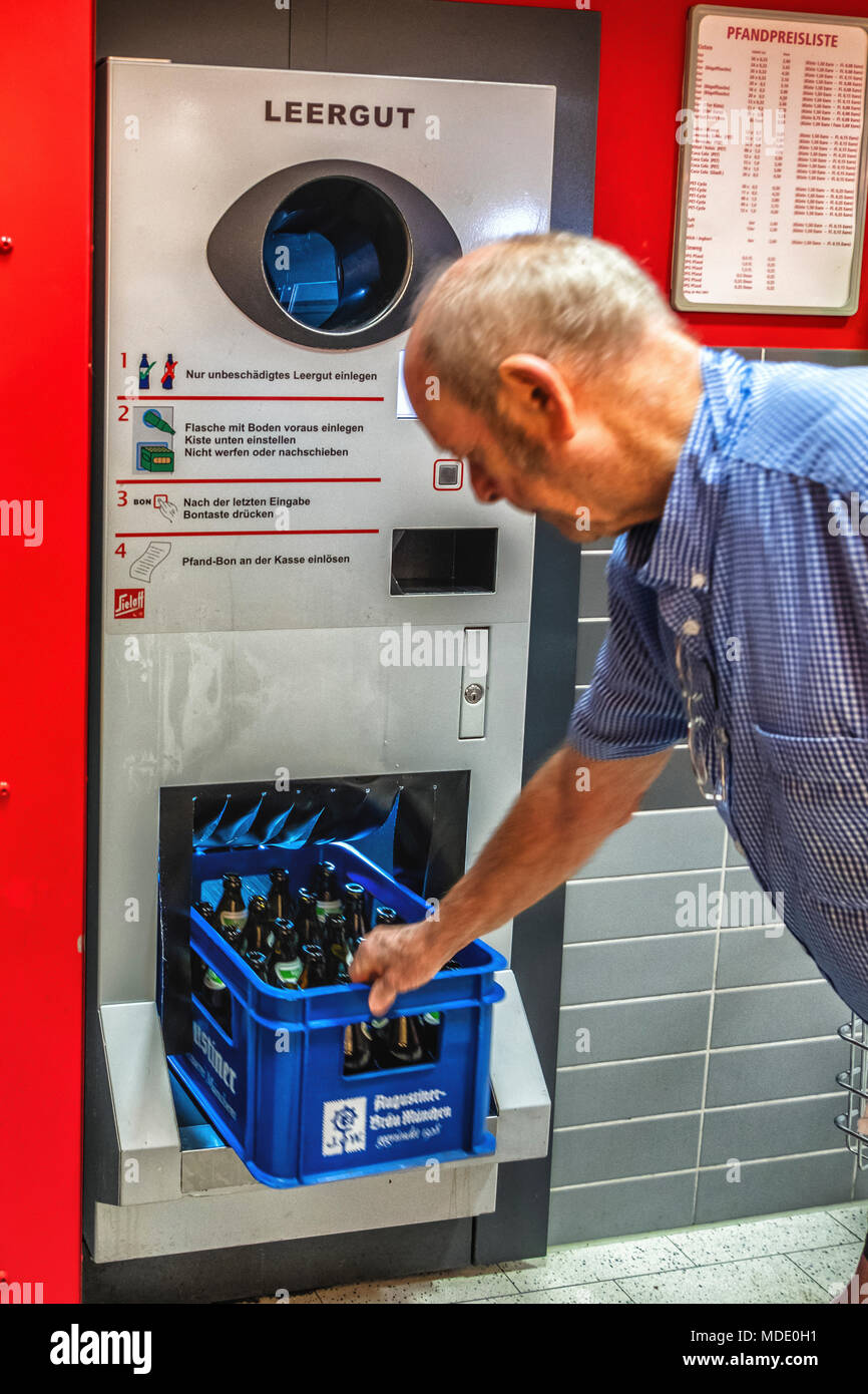 Berlin, Allemagne. Personnes âgées senior homme revenant des bouteilles vides d'un supermarché. Recyclage des bouteilles bouteille,recycle.pfand-system Banque D'Images