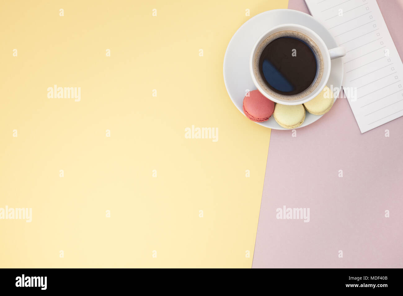 Télévision créative fixer photo de tasse à café et macarons et liste vide avec copie espace sur fond rose style minimal Banque D'Images