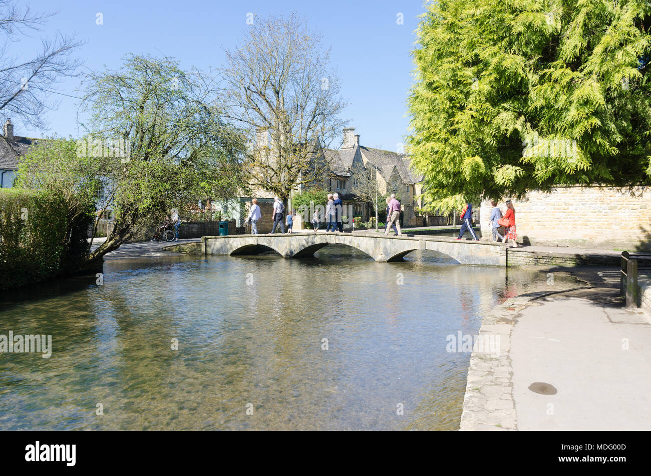 Les touristes sur la rive de la rivière Windrush dans le populaire village de Cotswold Bourton-on-the-water, Gloucestershire dans soleil du printemps Banque D'Images