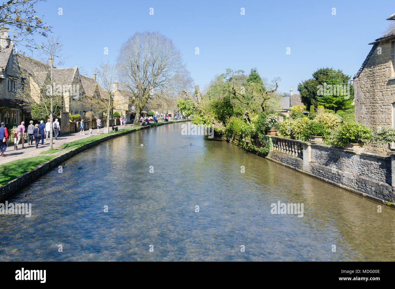 Les touristes sur la rive de la rivière Windrush dans le populaire village de Cotswold Bourton-on-the-water, Gloucestershire dans soleil du printemps Banque D'Images
