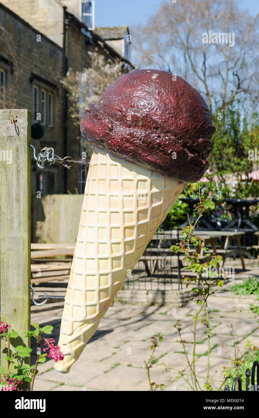 Gros cornet de crème glacée à l'extérieur bar laitier dans le populaire village de Cotswold Bourton-on-the-water, Gloucestershire dans soleil du printemps Banque D'Images