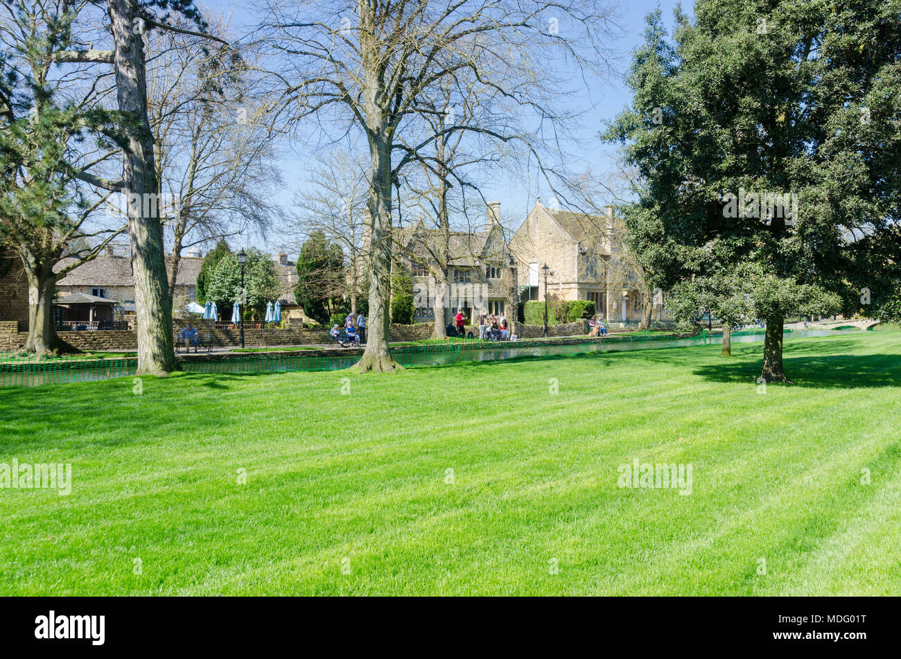 De l'herbe récemment fauché sur la rive de la rivière Windrush dans le populaire village de Cotswold Bourton-on-the-water, Gloucestershire dans soleil du printemps Banque D'Images