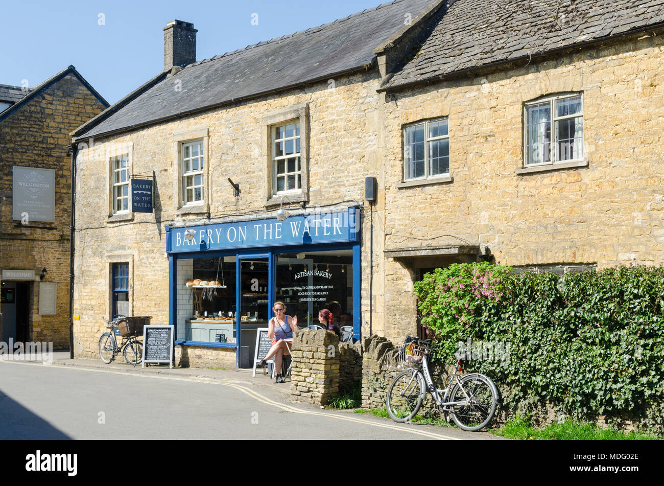 Sur la Boulangerie Boulangerie artisanale de l'eau dans le populaire village de Cotswold Bourton-on-the-water, Gloucestershire dans soleil du printemps Banque D'Images