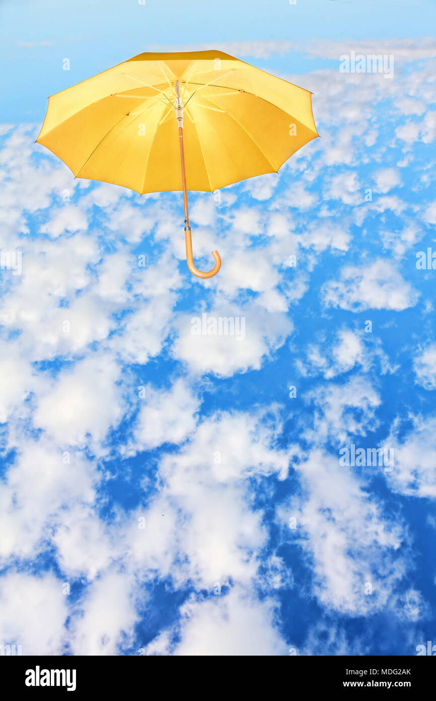 Mary Poppins.parapluie Parapluie ciel jaune va à l'encontre de nuages blancs.vent de changement concept. Banque D'Images