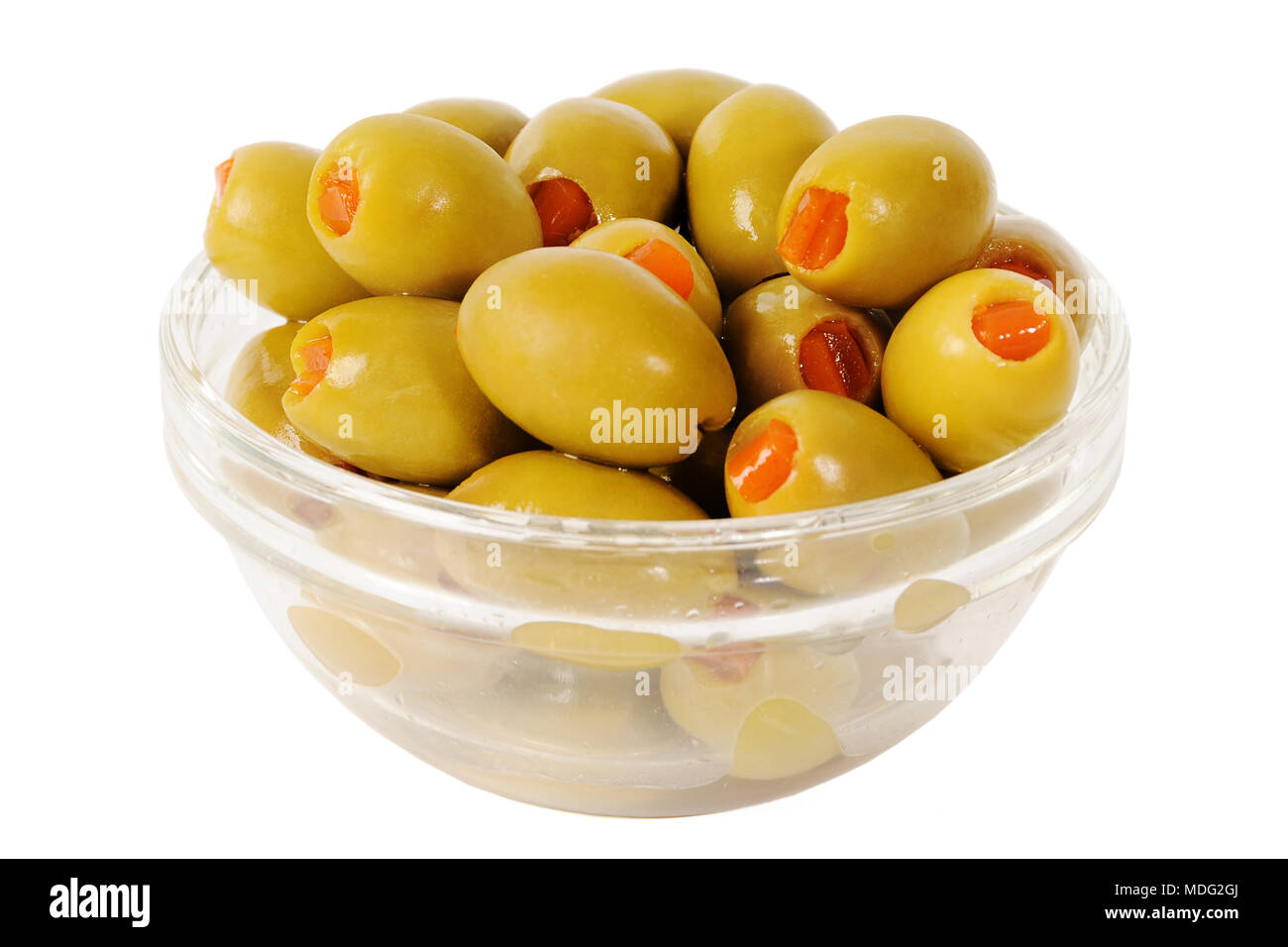 Olives vertes sans pierre dans un bol. Rempli d'olive avec le poivre. Olive verte dans un bol en verre isolé sur fond blanc Banque D'Images