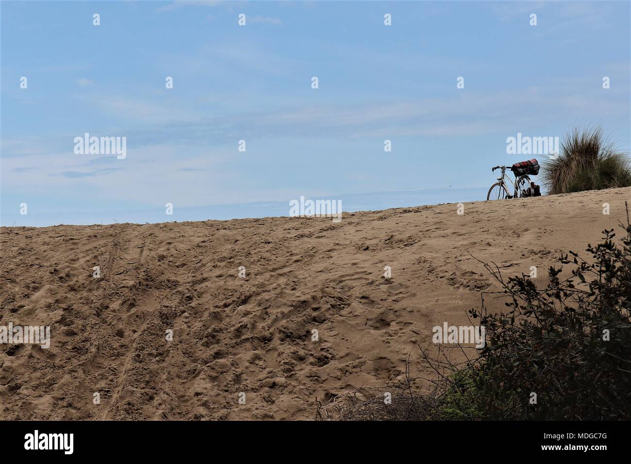 Un vélo est garé sur les dunes de sable - peut-être pour un pique-nique, et le surf dans l'Atlantique près de l'Amelie, Gironde Banque D'Images