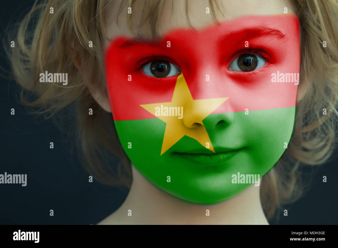 Enfant avec un drapeau peint du Burkina Faso Banque D'Images