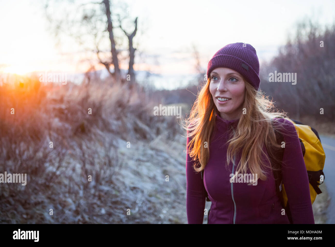 Une jeune femme portant un sac à dos et marcher au lever du soleil, Anchorage, Alaska, États-Unis d'Amérique Banque D'Images