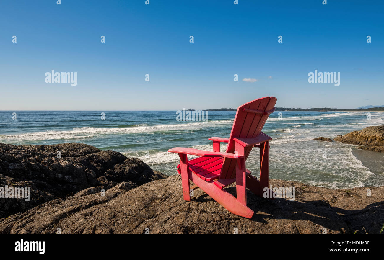 Un fauteuil Muskoka rouge sur la rive le long de la côte, le parc national Pacific Rim, l'île de Vancouver, Colombie-Britannique, Canada Banque D'Images