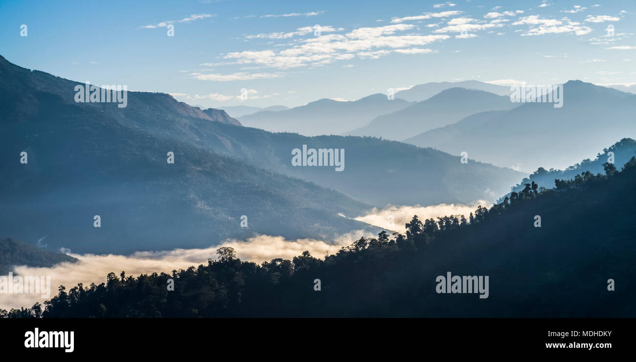 La lumière du soleil illumine les nuages situé bas dans la vallée dans l'Himalaya, Bengale occidental, Inde Banque D'Images