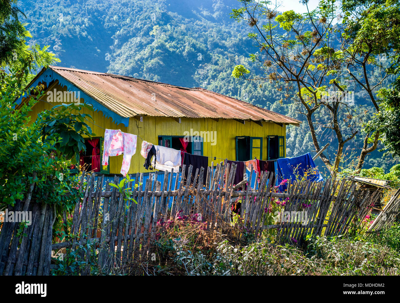Une maison jaune vif avec garniture bleue et une corde à pendre à l'extérieur dans l'Himalaya, Bengale occidental, Inde Banque D'Images