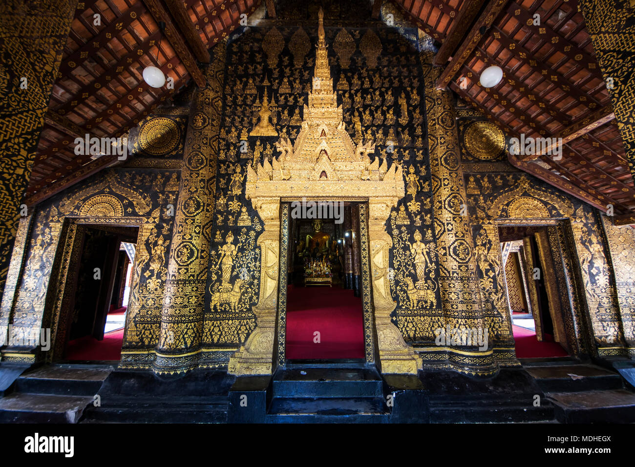 Les colonnes au pochoir noir et or sur le portique de la congrégation (SIM) hall de Wat Xieng Thong, Luang Prabang, Laos Banque D'Images