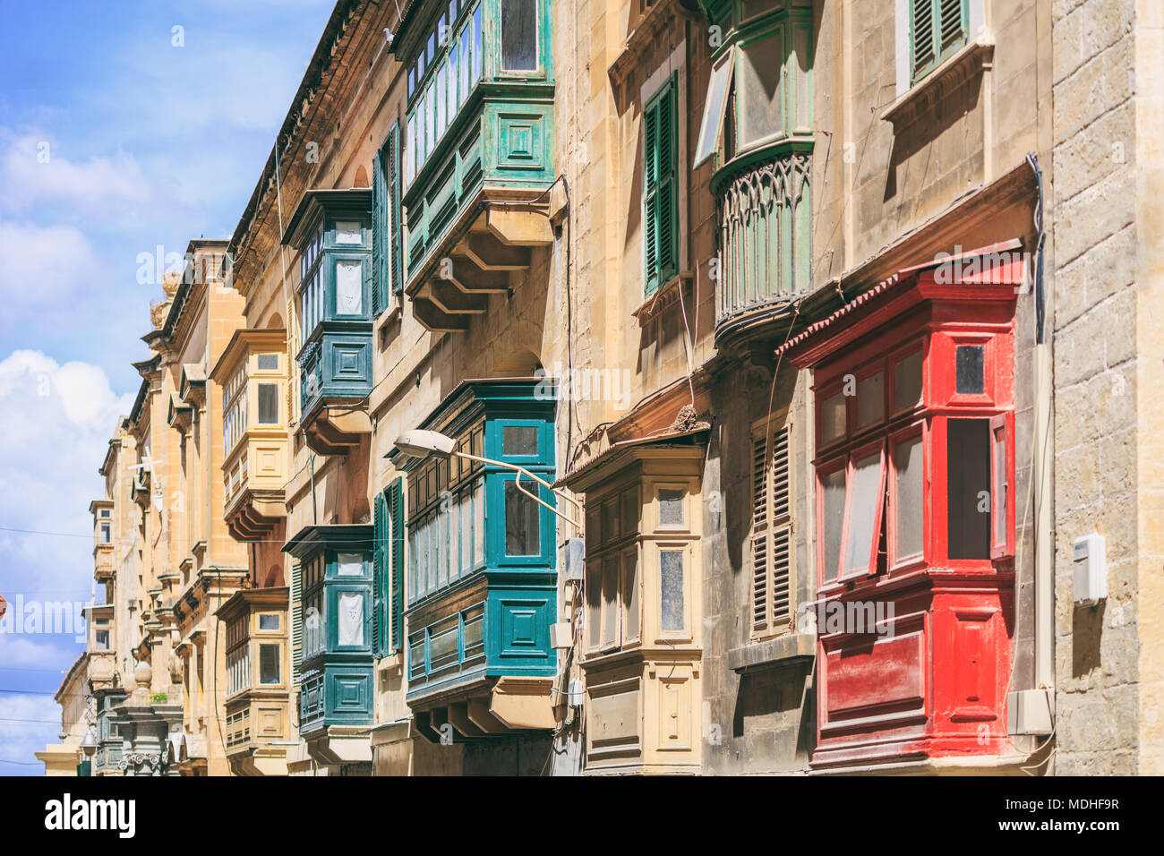 Malte, La Valette, maison traditionnelle la façade de l'immeuble avec des grès et balcons couverts, avec fond de ciel bleu, vue en perspective Banque D'Images