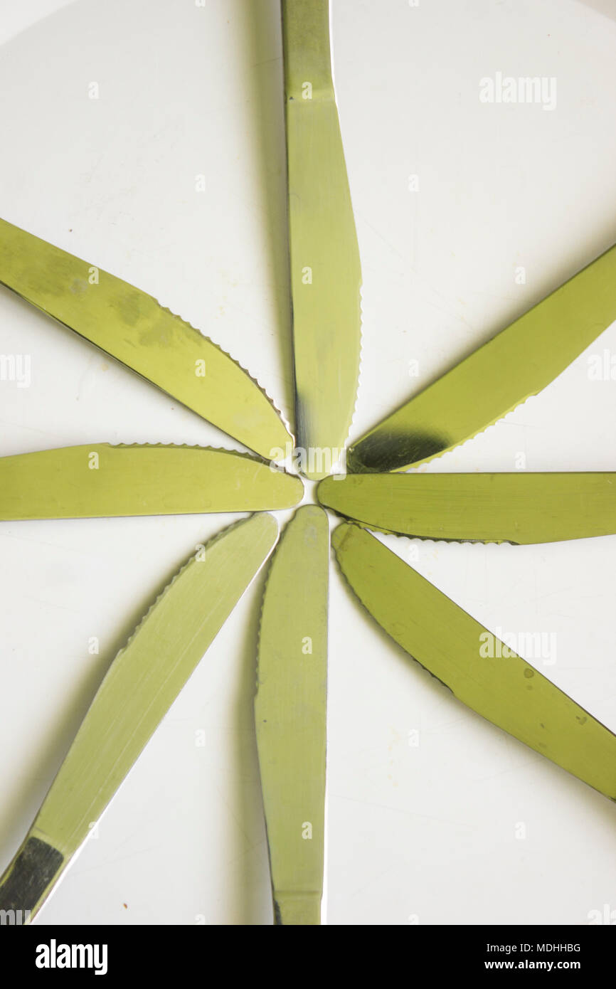 Huit couteaux pointant vers le centre formant une étoile sur fond blanc Banque D'Images