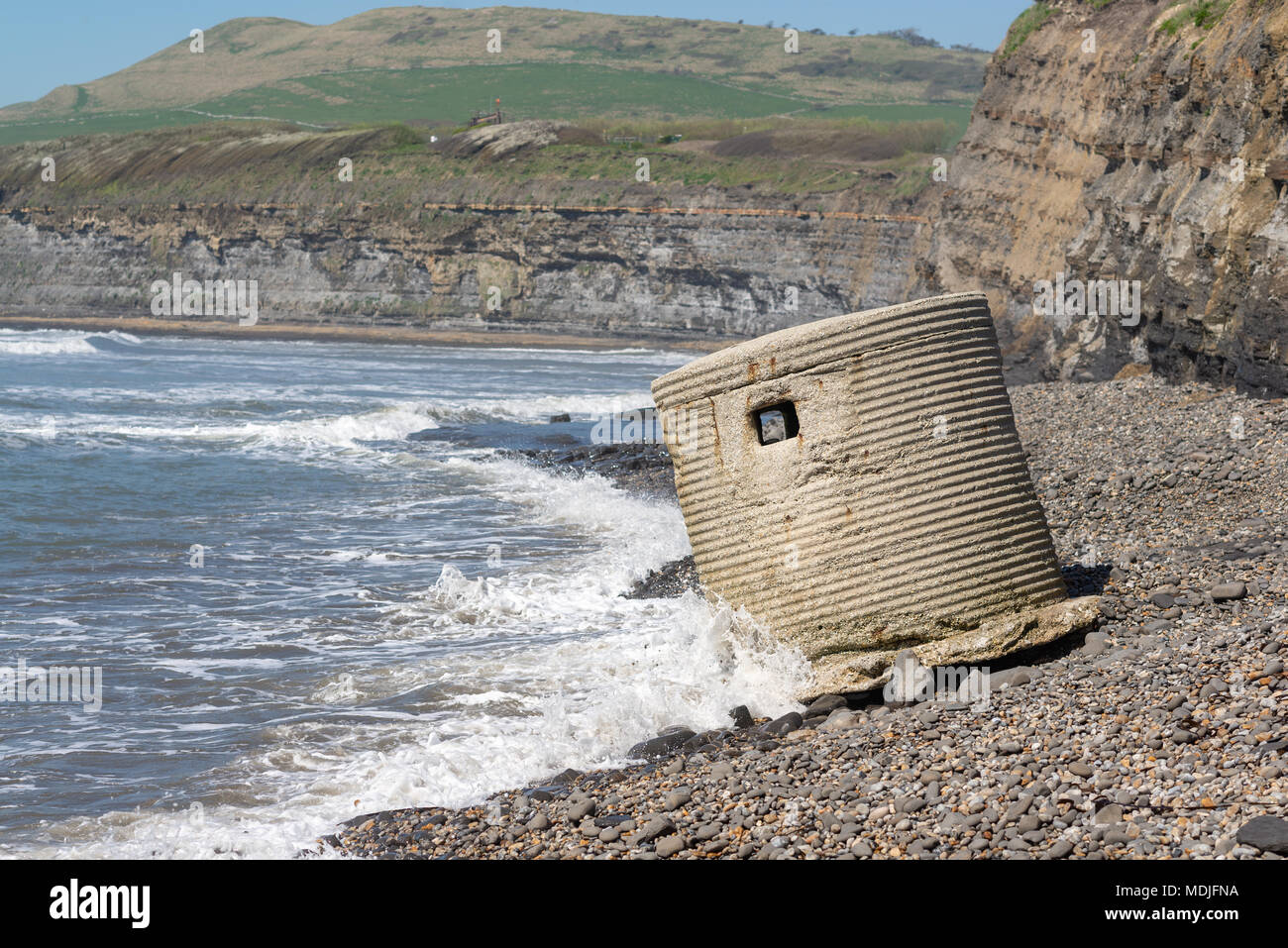Les vagues déferlent à une ruine d'un incliné WWII comprimé fort poste de guet sur la plage de la baie de Kimmeridge, Dorset, UK Banque D'Images