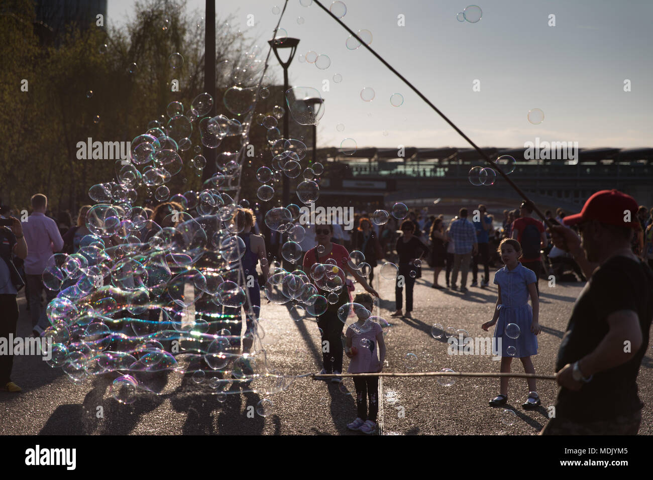 Londres, Royaume-Uni. 19 avril, 2018. Météo France : un musicien ambulant fait de bulles de passants sur la rive sud de la Tamise pendant un beau soir, à London, UK Crédit : Carol Moir Banque D'Images