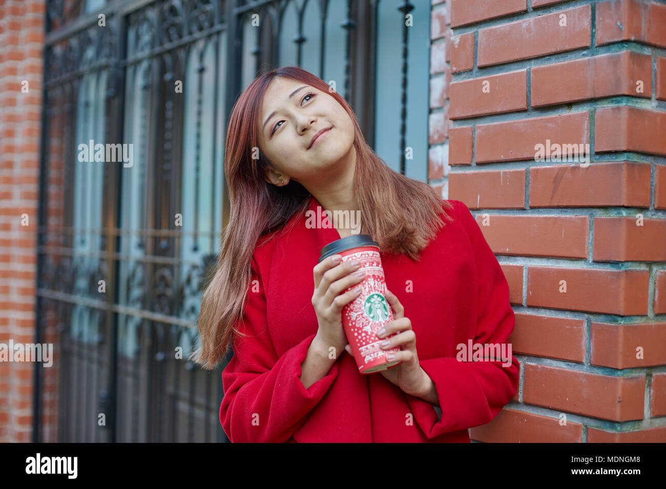 KALININGRAD, RUSSIE - circa 2017 SEPTEMBRE : outdoor portrait de jolie femme avec Starbucks tasse de papier jetables. Banque D'Images