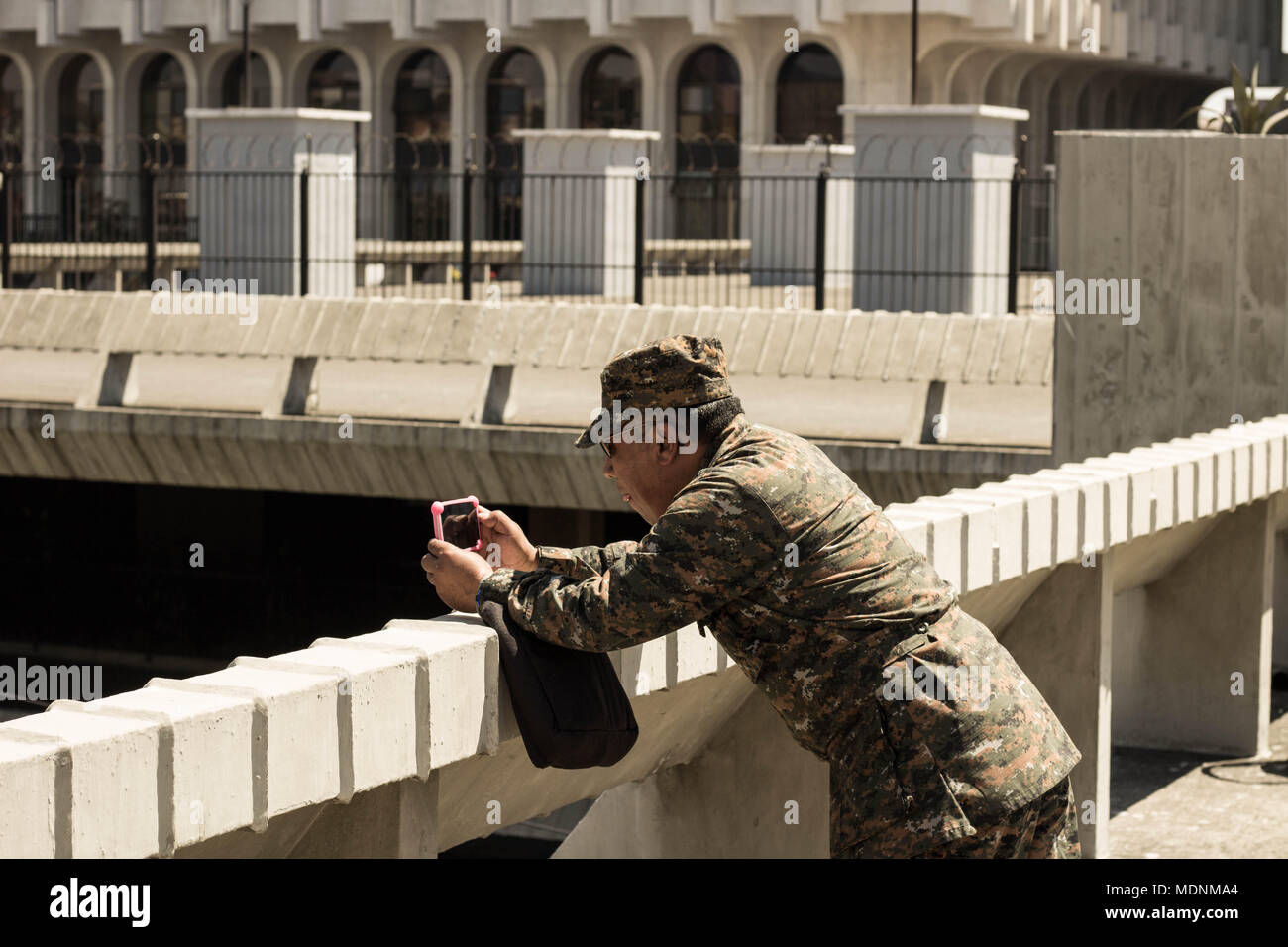 Un soldat de prendre une photo d'un défilé religieux Banque D'Images