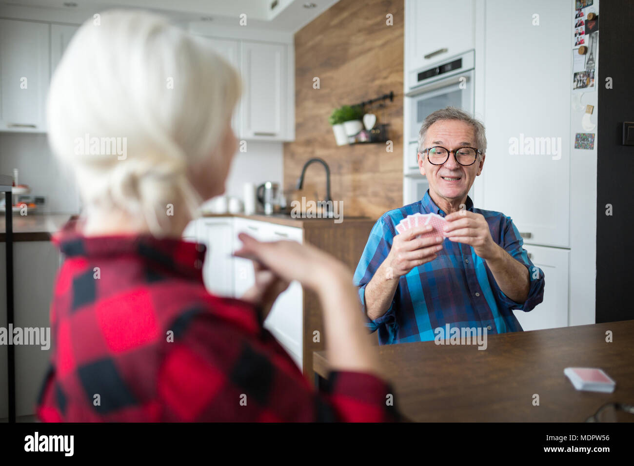 Portrait of senior couple cartes à jouer ensemble dans la cuisine Banque D'Images
