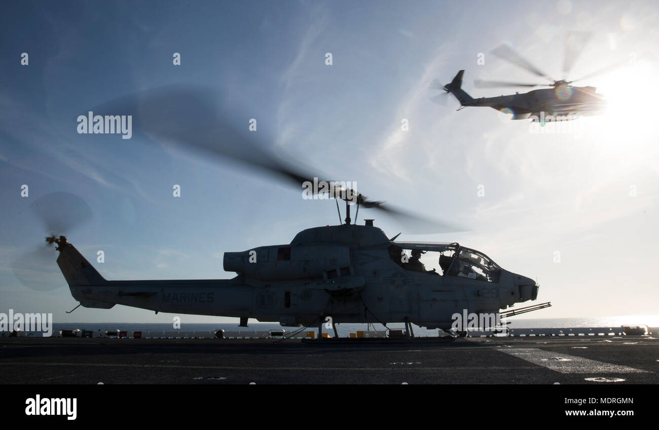 Un CH-53E Super Stallion vole au-dessus de la marche au ralenti un AH-1W Super Cobra, les deux avec 2'aile de l'avion, sur le pont de l'USS Kearsarge en route pour la Semaine de la Marine La Nouvelle Orléans le 19 avril 2018. La Semaine de la marine La Nouvelle Orléans en vedette de la Marine et du Corps des capacités de combat et fournit l'occasion pour le public de se renseigner sur l'interopérabilité entre les services. (U.S. Marine Corps photo par le Sgt. Justin T. Updegraff) Banque D'Images