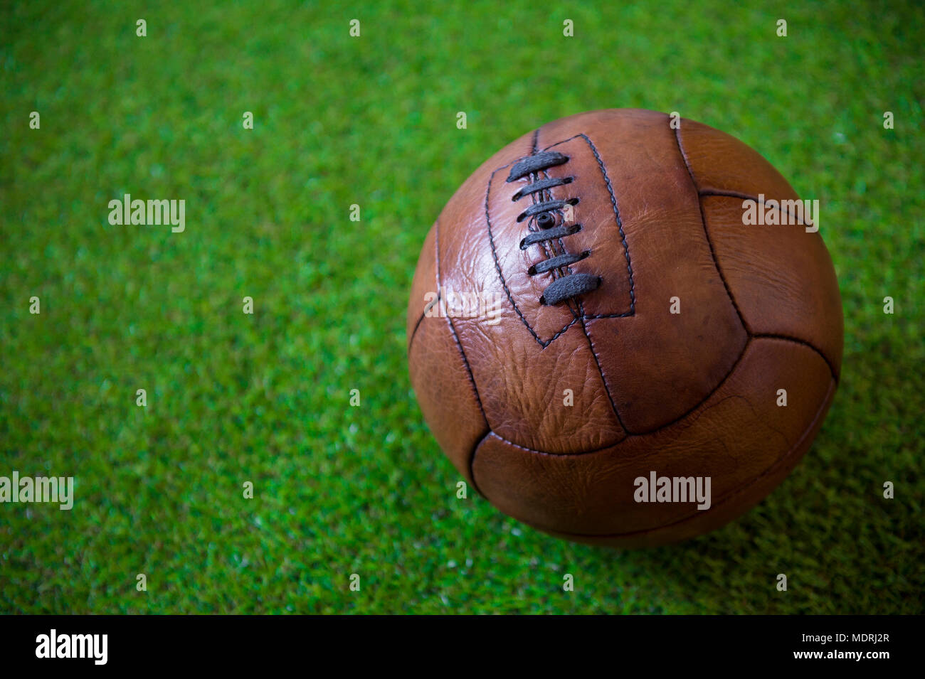 Vue rapprochée d'un vintage en cuir brun, (circa 1930) football sur fond d'herbe verte luxuriante Banque D'Images