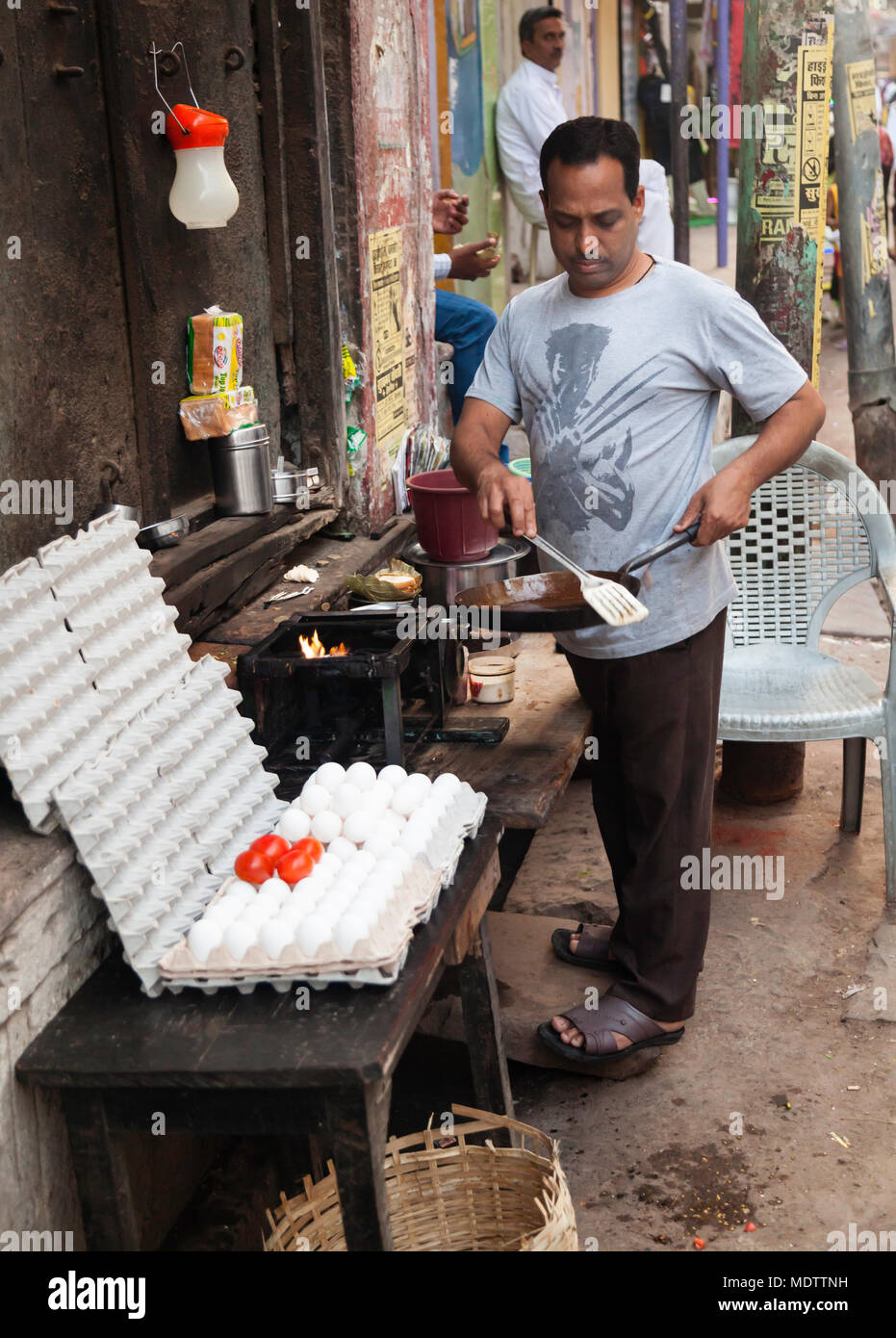 Sur une longue rue Varanasi ce monsieur fait omelette pour la vente. Banque D'Images