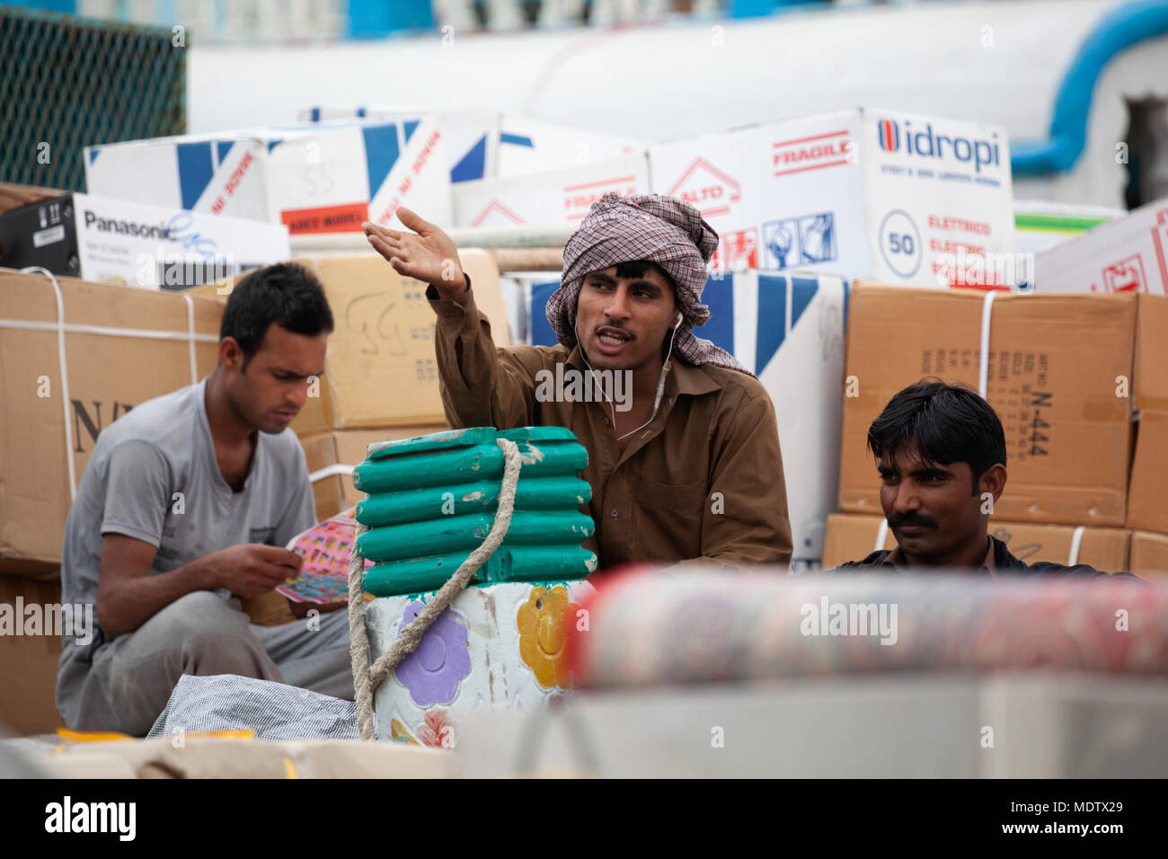 Ouvriers en tenant une pause du travail déchargement d'un bateau amarré le long de la Crique de Dubaï, Deira, Dubaï, Émirats arabes unis, Moyen Orient Banque D'Images