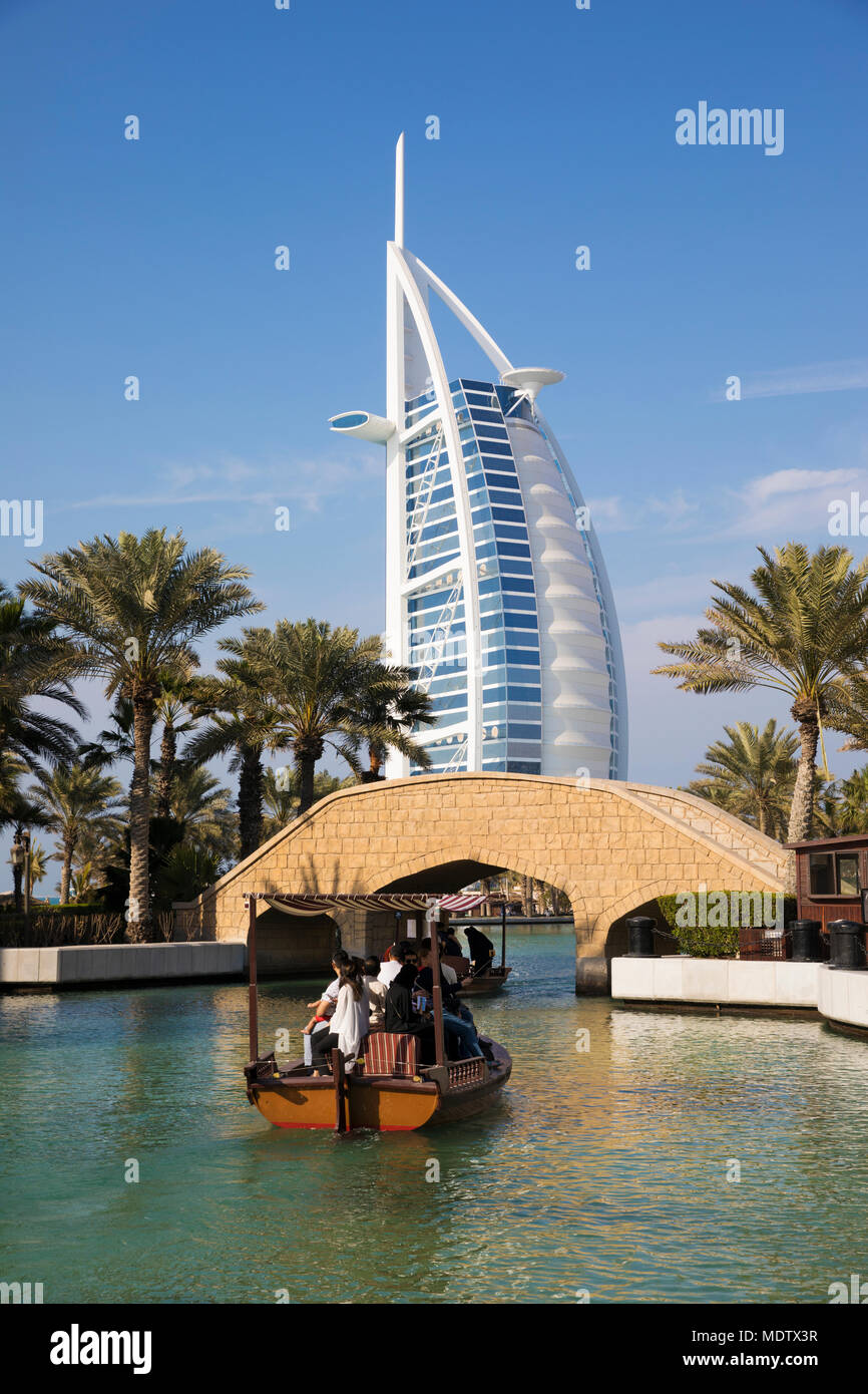 Les touristes à cheval sur un abra sur les voies navigables de l'Madinat Jumeirah avec le Burj Al Arab derrière, Dubaï, Émirats arabes unis, Moyen Orient Banque D'Images