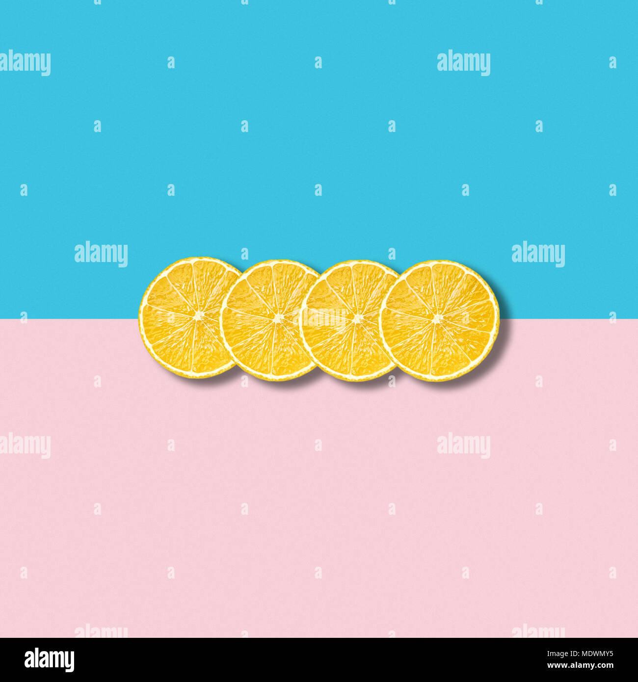 Un minimum d'abstract illustration avec groupe de tranches de citron sur fond turquoise et rose pastel Banque D'Images
