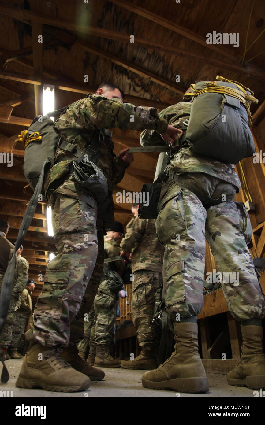 Les parachutistes de l'armée américaine don leurs parachutes avant de saut (JMPI Inspection personnelle) au cours de la 20e Conférence annuelle de Randy Oler Opération Memorial Toy Drop, organisé par l'armée américaine et des affaires civiles de la commande d'opérations psychologiques (Airborne), le 6 décembre, 2017 à MacKall Army Airfield, Caroline du Nord. Jouet opération Drop est la plus grande opération aéroportée combiné avec neuf pays partenaires participant parachutistes et permet aux soldats la possibilité de s'entraîner sur leurs spécialités professionnelles militaires, maintenir leur préparation à l'aéroporté, et donner en retour à la communauté locale. (U.S. Photo de l'armée par le Sgt John Jo Banque D'Images